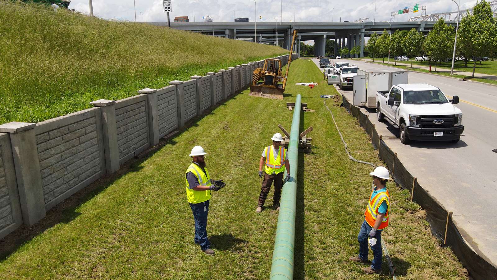 Utility workers next to a large natural gas pipe