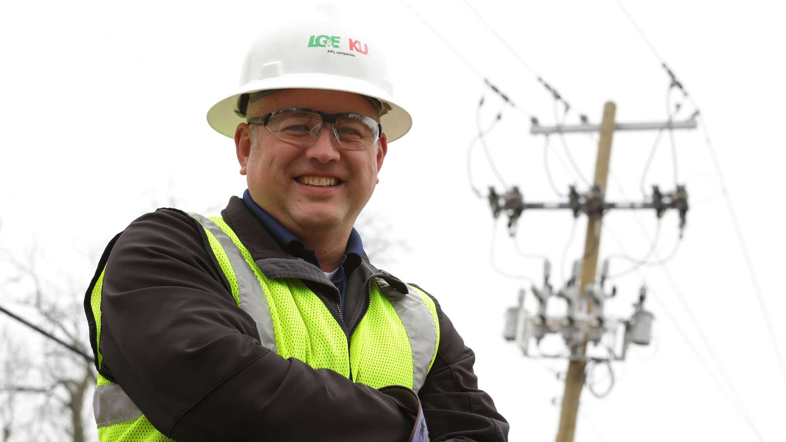 Lineman standing in front of a utility pole with reclosers