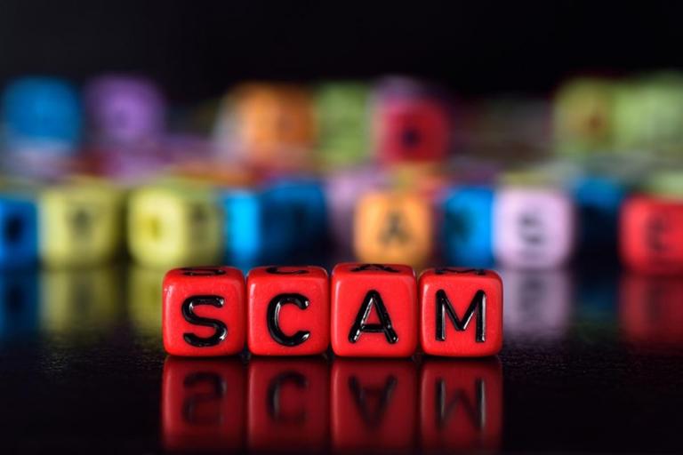the word scam made up of red bracelet cubes